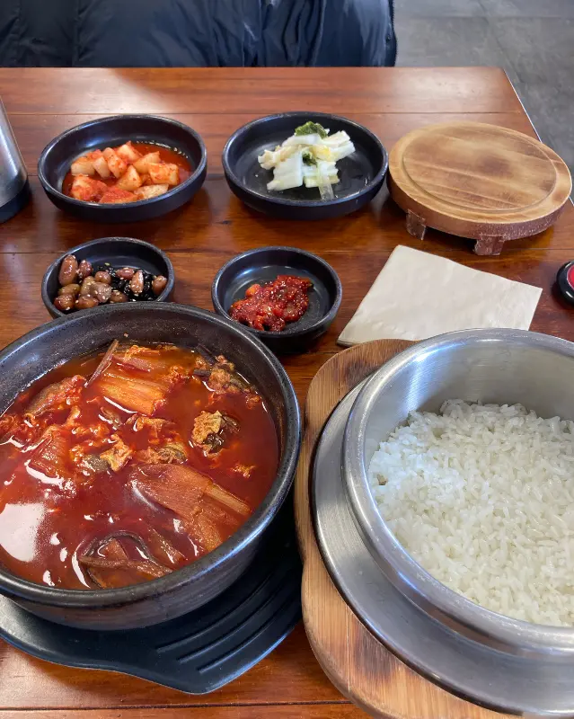 소반뜰의 제육볶음 정식. 솥밥과 육개장, 제육볶음, 그리고 정갈한 반찬들이 한 상 가득 차려져 있다.