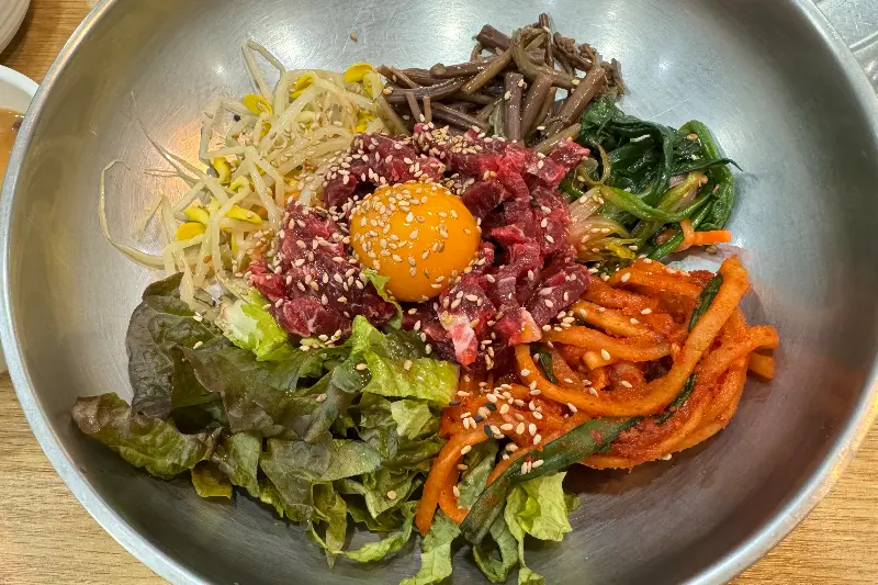 고소한 참깨가 뿌려진 생고기 비빔밥