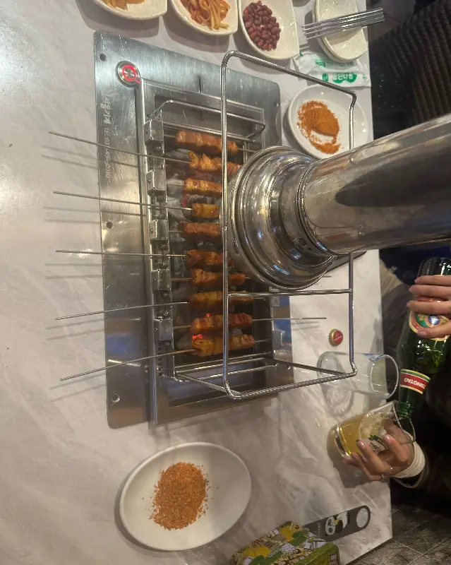 자동 꼬치 기계에서 익어가는 양꼬치