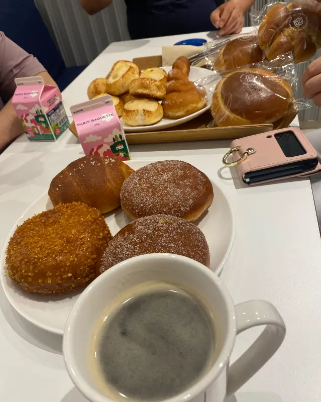 테이블 위에 놓인 다양한 빵과 커피