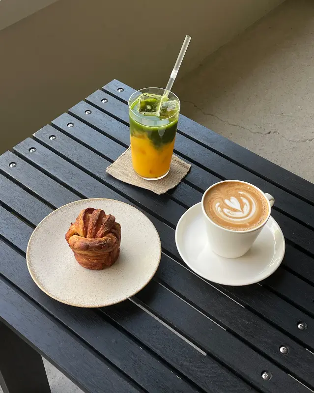 크림 라떼와 시나몬 롤이 테이블 위에 놓여있는 모습