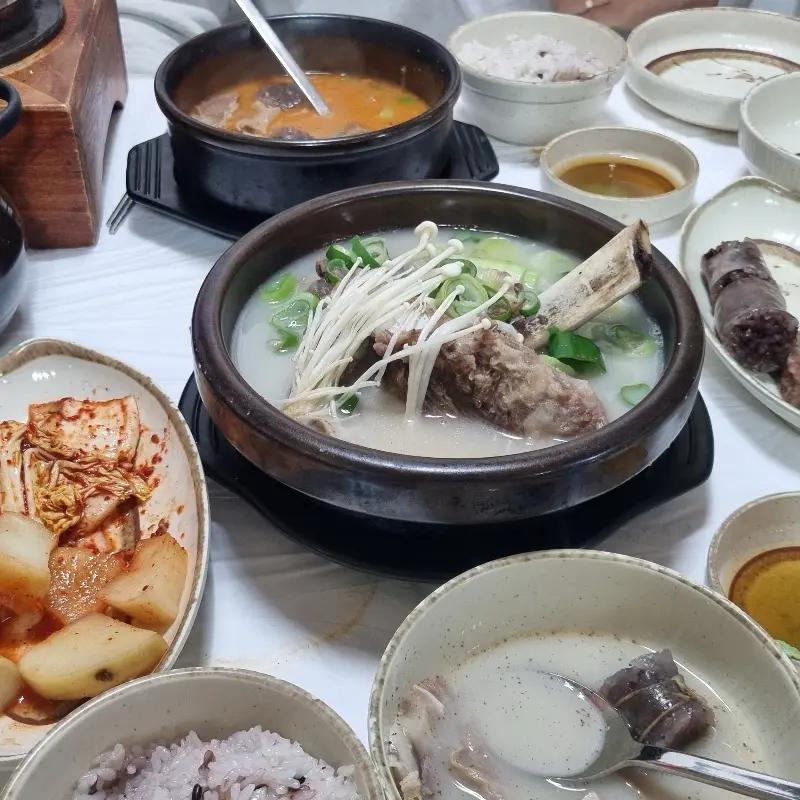 돌솥밥, 김치, 깍두기, 순대, 왕갈비곰탕이 차려진 푸짐한 테이블