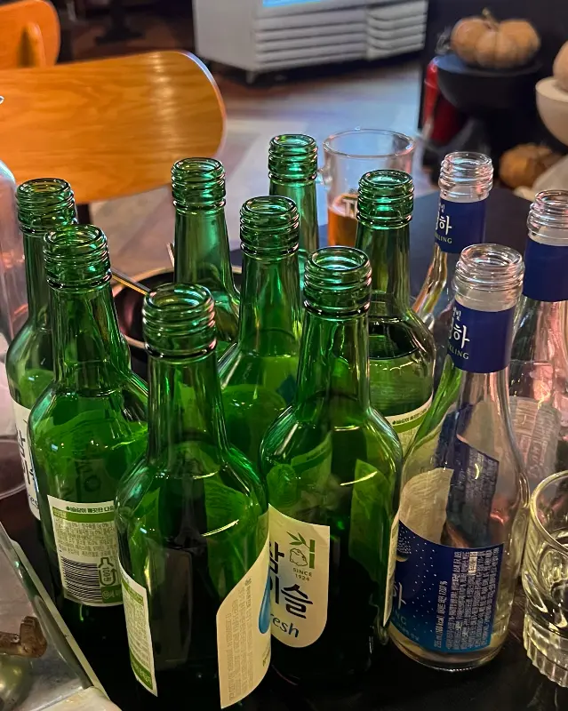테이블 위에 놓인 여러 병의 소주병 사진