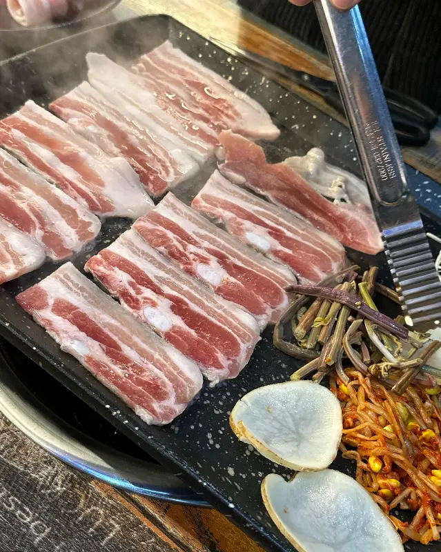 불판에 가지런히 놓인 삼겹살