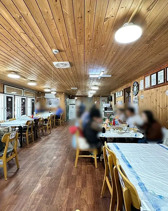 넓고 테이블이 많이 놓여있는 식당 내부 전경