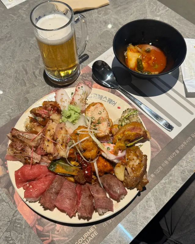 고기, 초밥, 샐러드 등 푸짐하게 담긴 접시