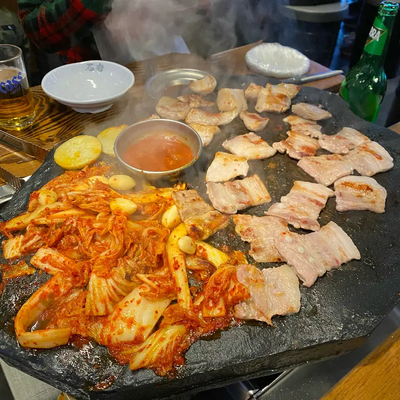 돌판 위에 올려진 김치와 삼겹살