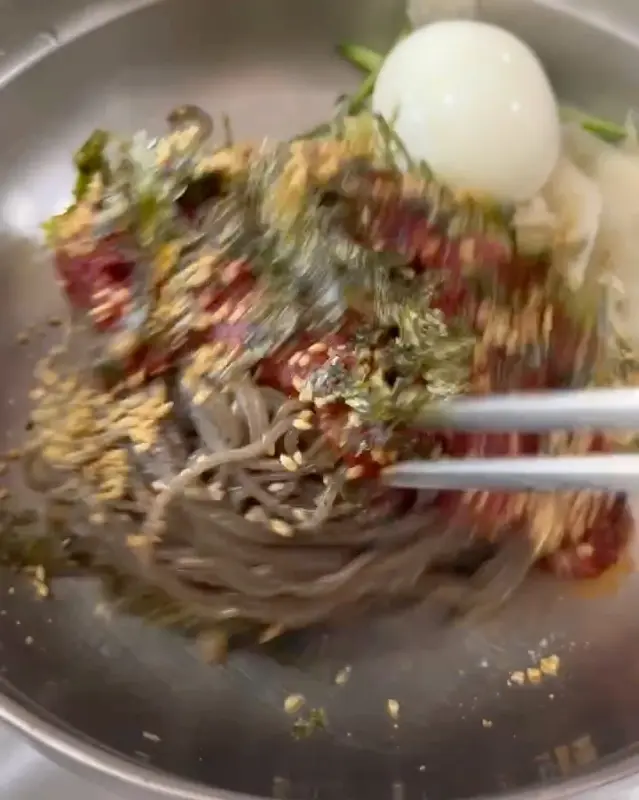 젓가락으로 비빔 막국수를 비비는 모습