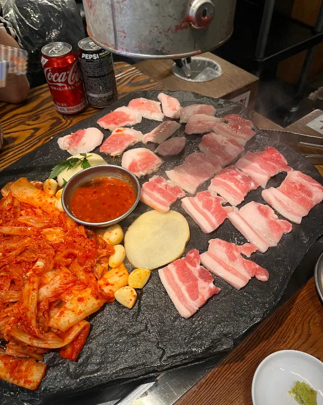 돌판에 김치와 삼겹살이 구워지는 모습