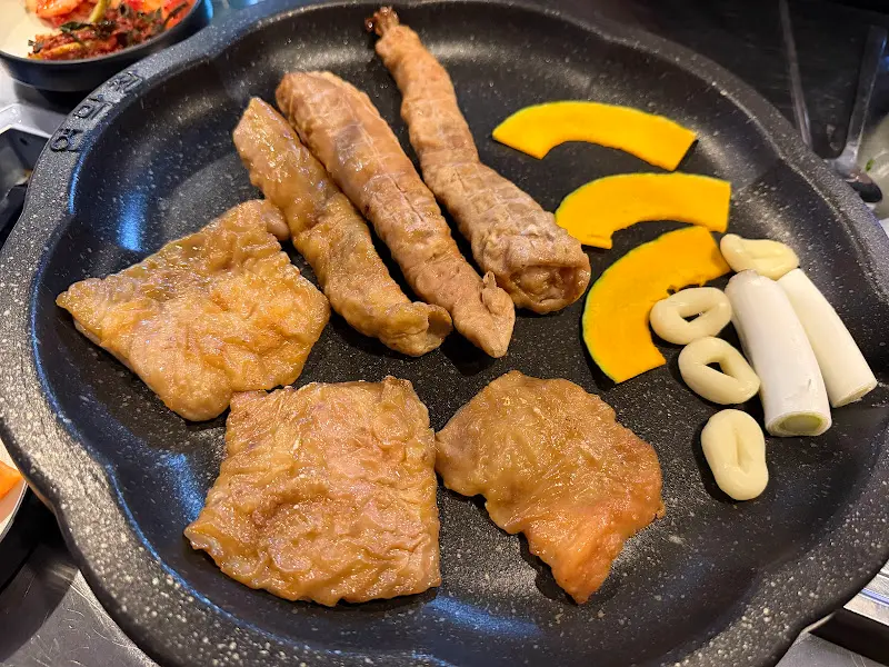 불판 위에 올려진 막창과 곁들임 재료들