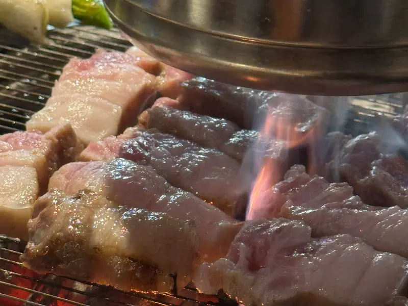 숯불 위에서 익어가는 두툼한 고기