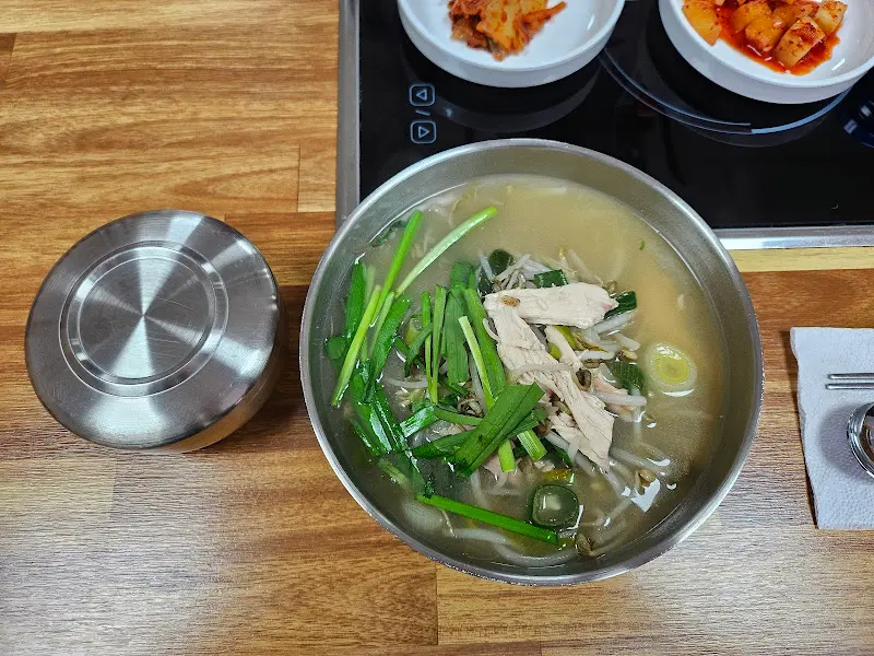 나무 테이블 위에 놓인 닭곰탕과 뚜껑