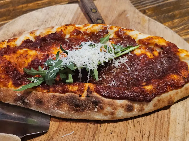 나무 도마 위에 올려진 깔조네 피자