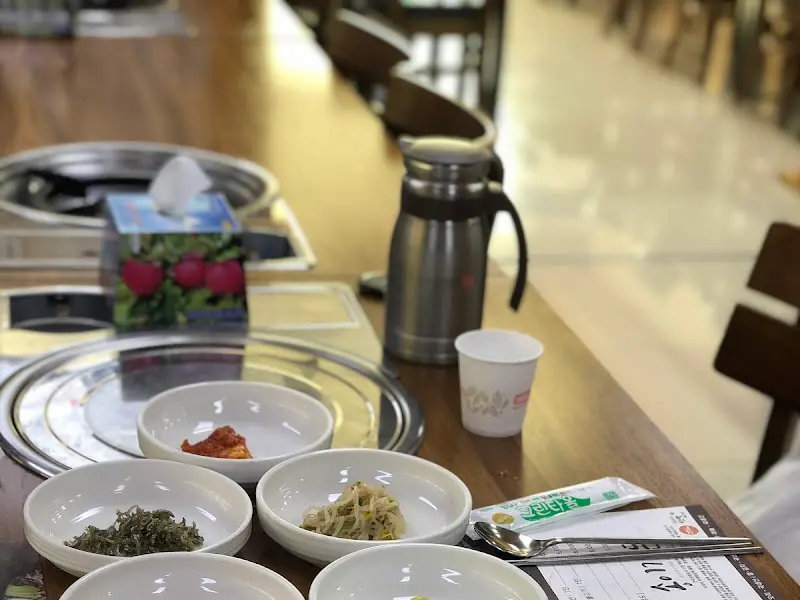 테이블 위에 놓인 몇 개의 작은 흰색 그릇에 담긴 다양한 반찬 클로즈업 샷.