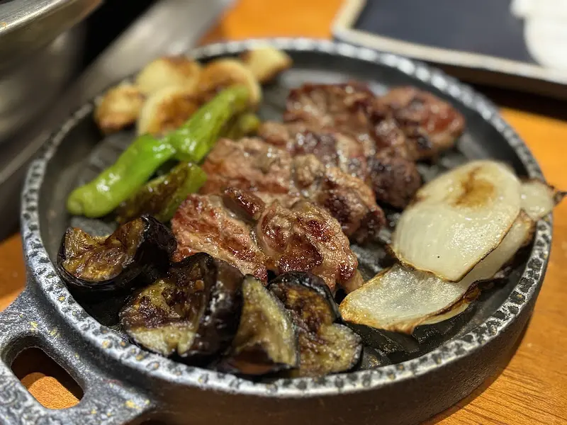 불판 위에서 맛있게 익어가는 양고기, 마늘, 가지, 꽈리고추