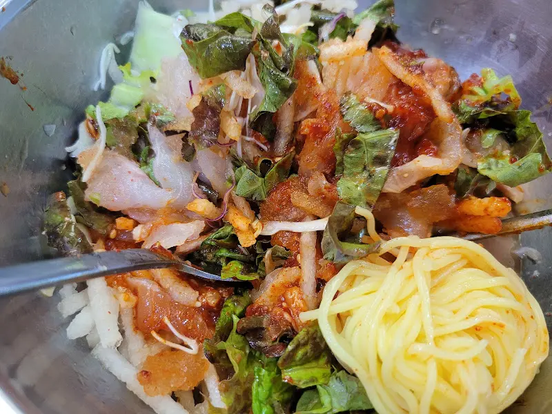 물회에 육수를 부은 후 비비는 모습