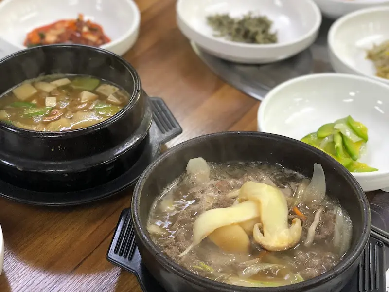 테이블 위에 놓인 다양한 반찬과 뚝배기에 담긴 국 클로즈업.