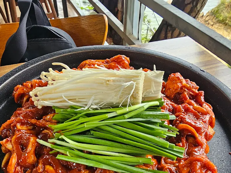 불판 위에서 익어가는 오리불고기와 팽이버섯, 부추