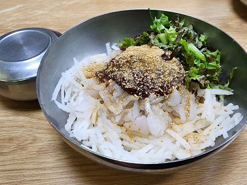 물회에 소면을 넣어 비벼 먹는 모습