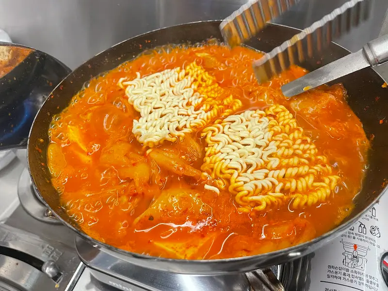 김치찌개에 라면사리를 넣어 끓이는 모습이 먹음직스럽다.