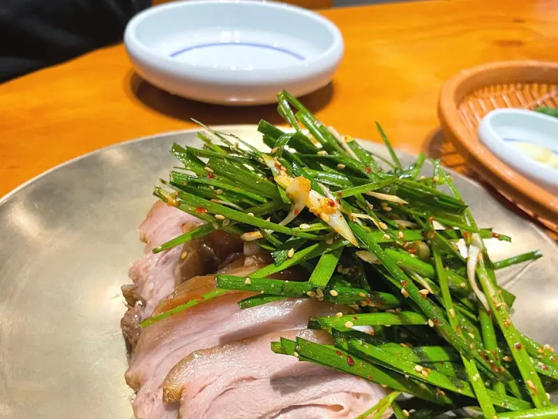 윤기가 흐르는 수육과 싱싱한 부추의 조화