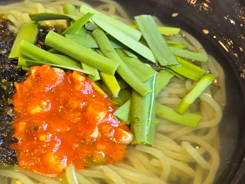 비빔국수의 매콤한 양념과 신선한 야채 고명