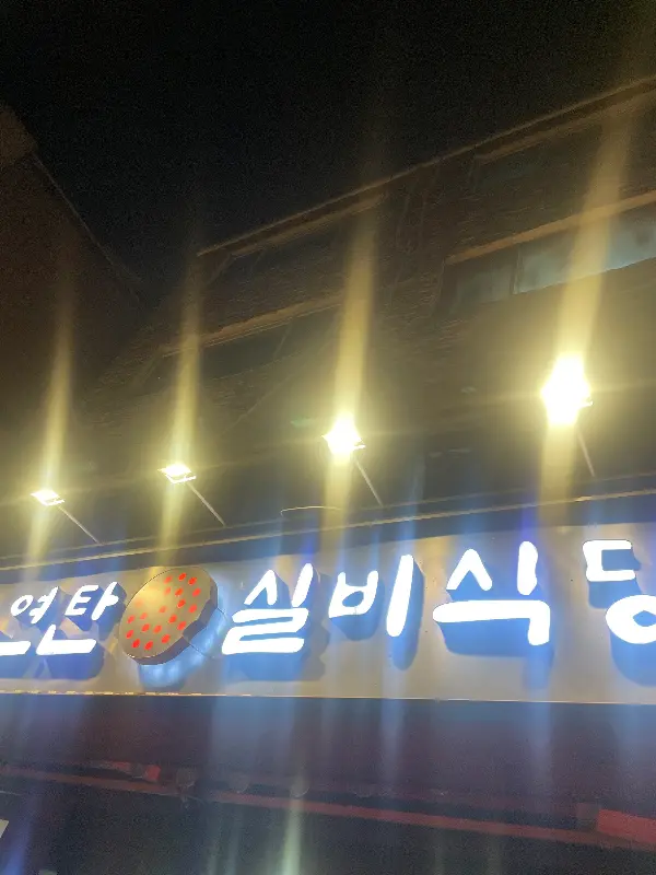 밤에 빛나는 연탄실비식당 간판