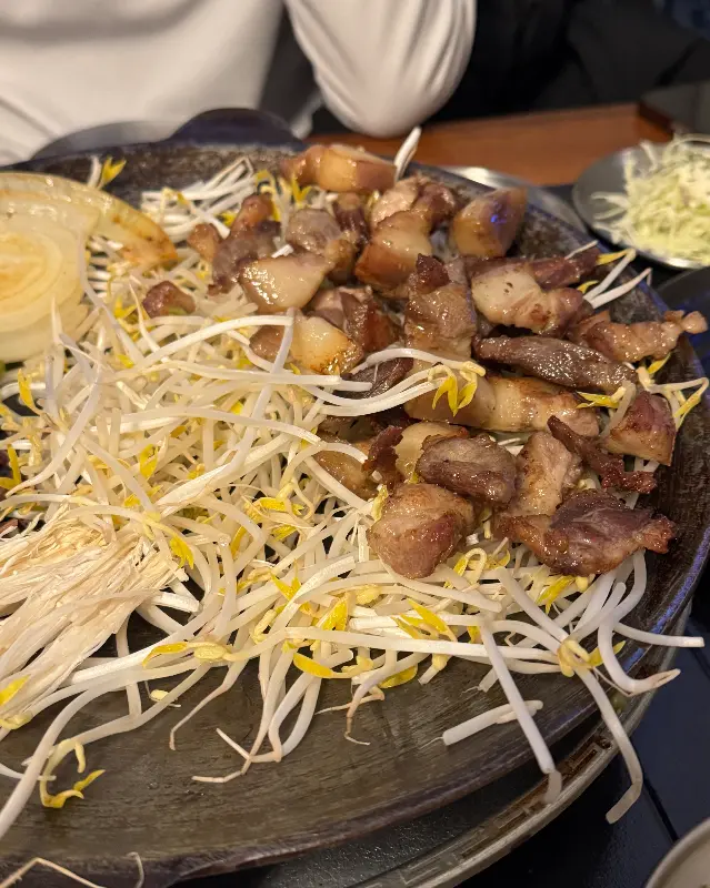 고기와 콩나물이 푸짐하게 담겨 나온 철판의 모습