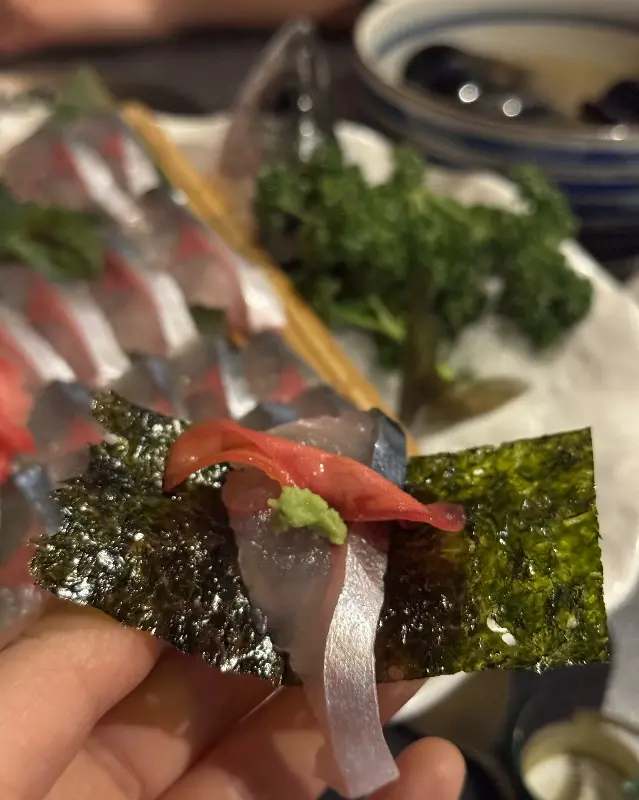 김에 고등어회와 와사비를 올려 먹는 모습