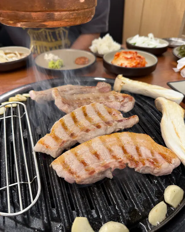 불판 위에서 구워지는 삼겹살과 마늘