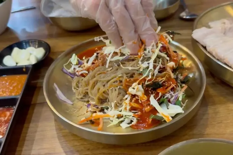 예가족발 막국수 비비는 모습