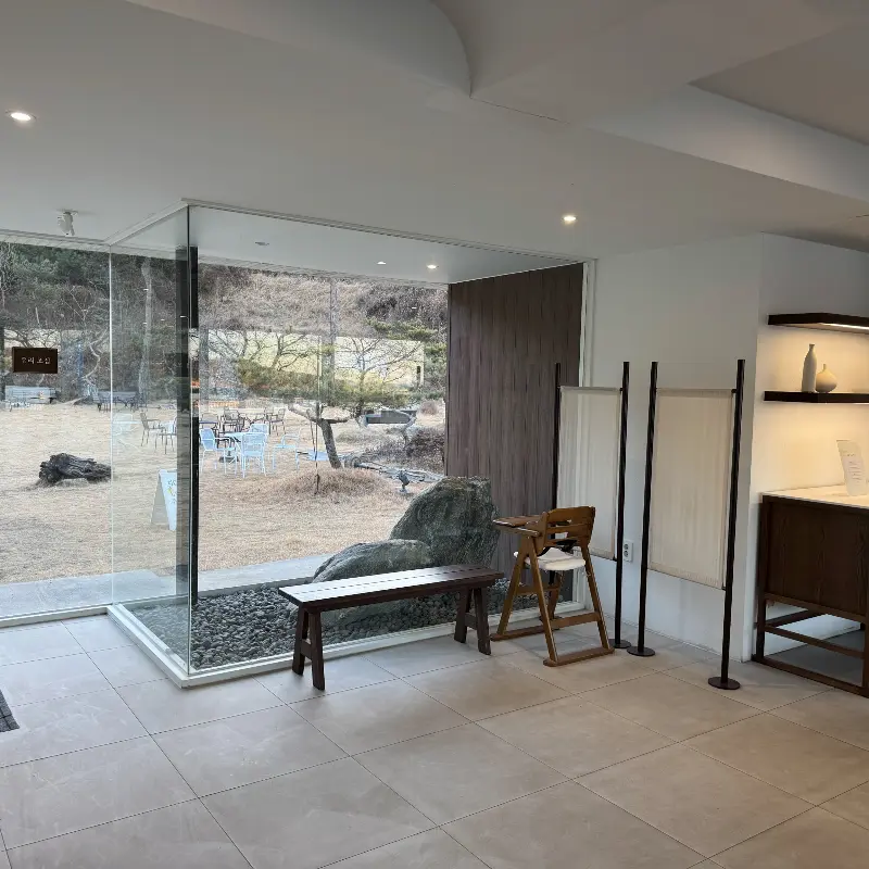 통유리창을 통해 정원이 보이는 카페 내부