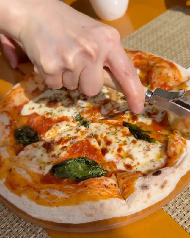 마르게리따 피자를 자르는 모습