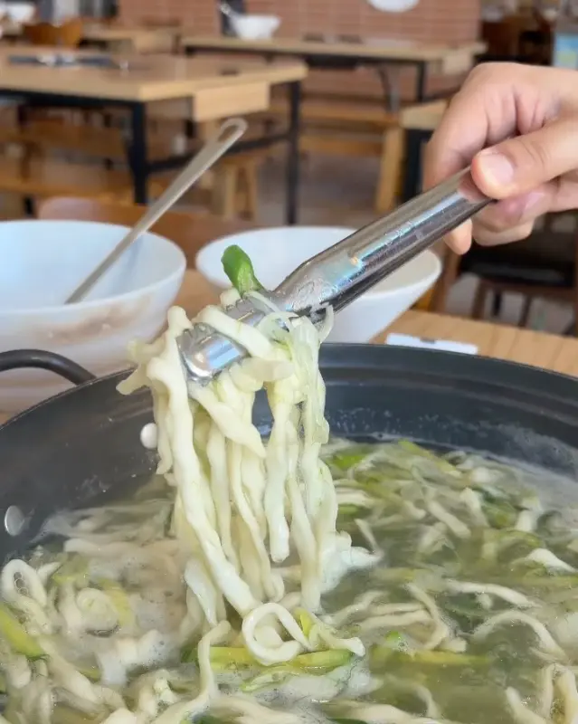백합칼국수의 쫄깃한 면발을 집어 올리는 모습