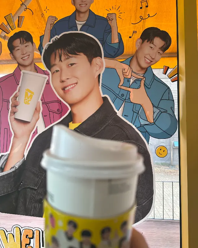 메가커피 광고 모델 사진. 밝은 미소가 인상적이다.