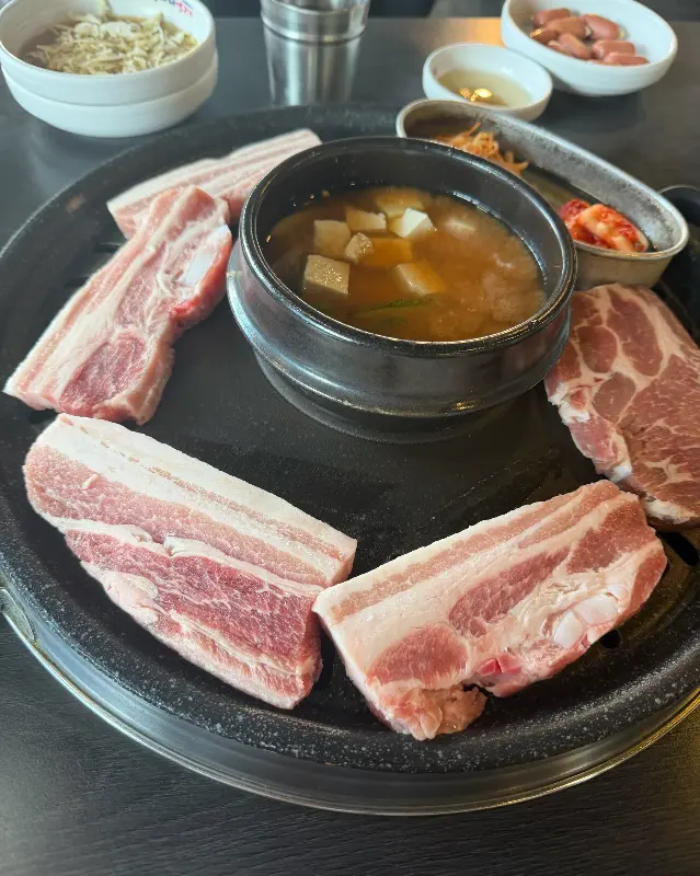 불판 위 삼겹살과 된장찌개