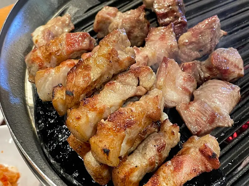 숯불 위에서 맛있게 구워진 삼겹살과 목살