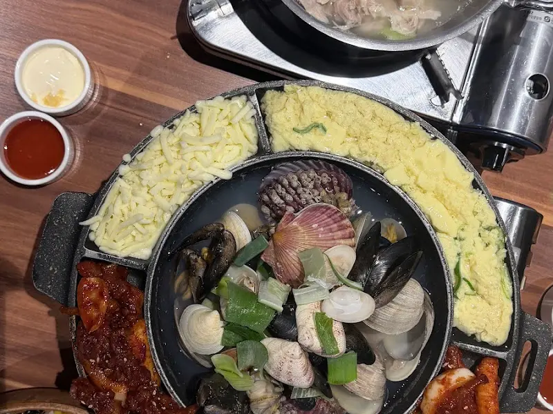 닭발, 조개탕, 계란찜, 치즈가 함께 나오는 메뉴의 항공샷