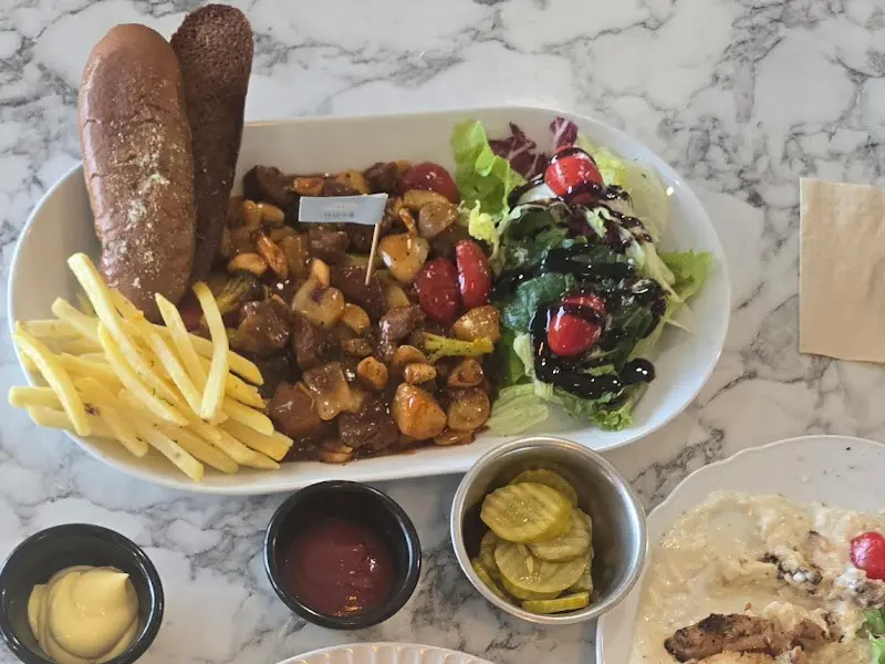 스테이크, 샐러드, 감자튀김, 빵이 함께 나오는 메뉴