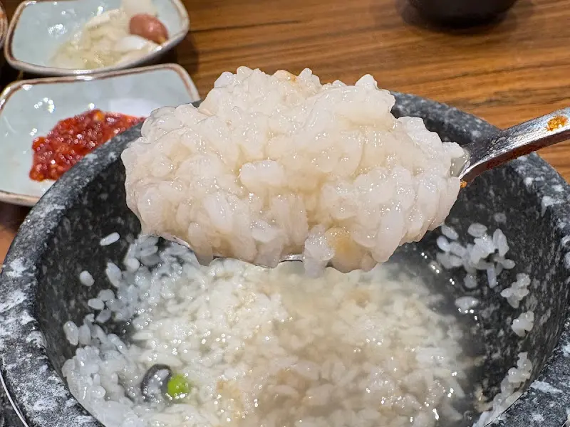 돌솥에 담긴 밥을 숟가락으로 크게 떠올린 모습