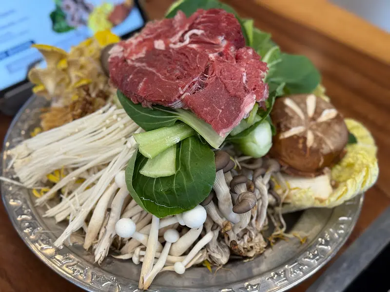 다양한 버섯과 채소, 소고기가 담긴 접시