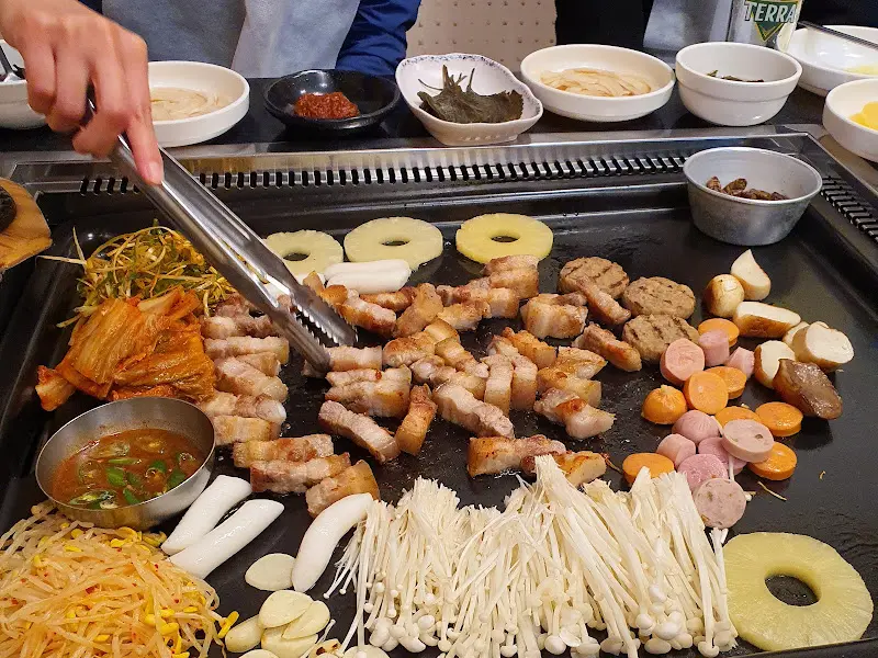 맛있게 구워진 삼겹살을 집어 드는 손길