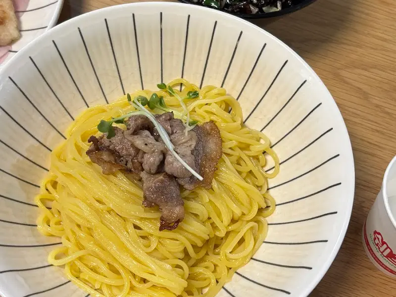 윤기가 흐르는 면 위에 고기가 올려진 짜장면의 모습