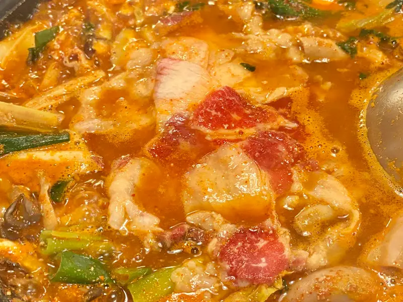 차돌박이가 추가된 곱창전골의 모습. 붉은 육수와 차돌박이의 마블링이 조화롭다.