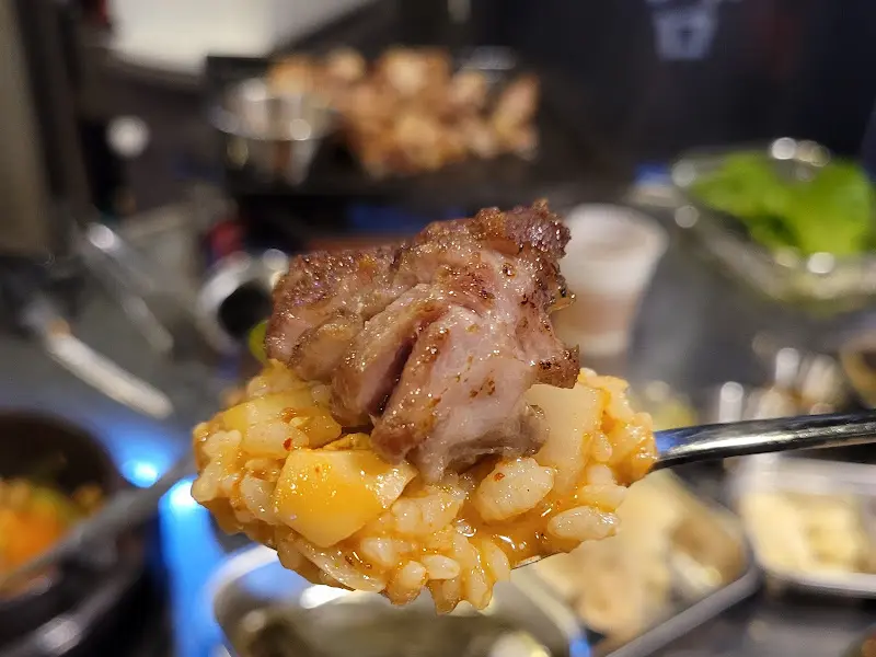 윤기가 자르르 흐르는 오겹살 한 점을 숟가락 위에 올린 모습