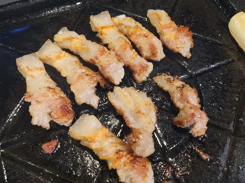 불판 위에서 노릇하게 구워진 오겹살 조각들