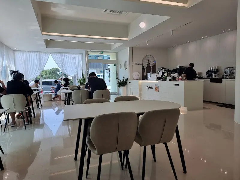 카페 내부의 테이블과 의자가 놓여 있는 모습. 전체적으로 밝고 깔끔한 분위기이다.