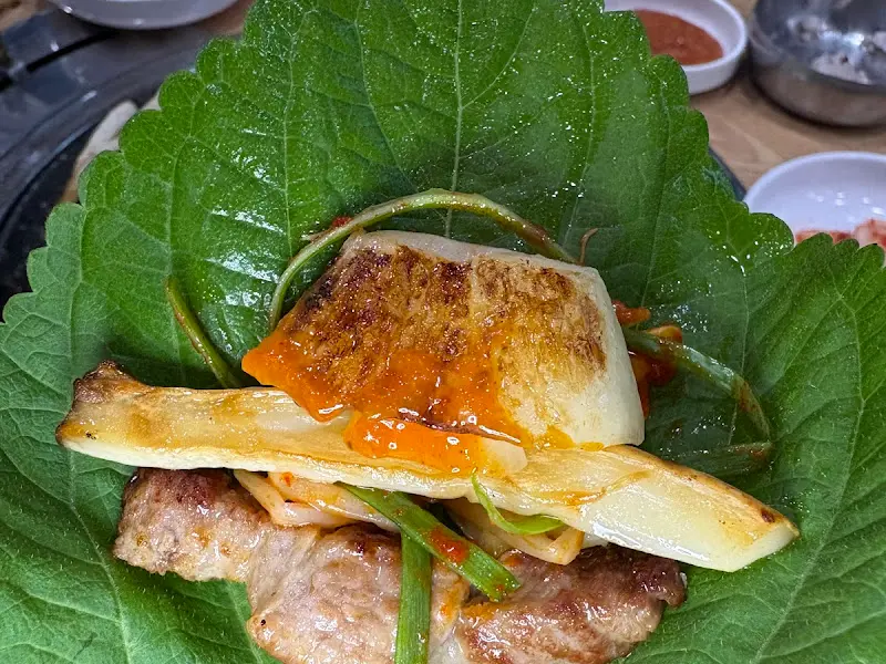 깻잎 위에 올려진 삼겹살 쌈