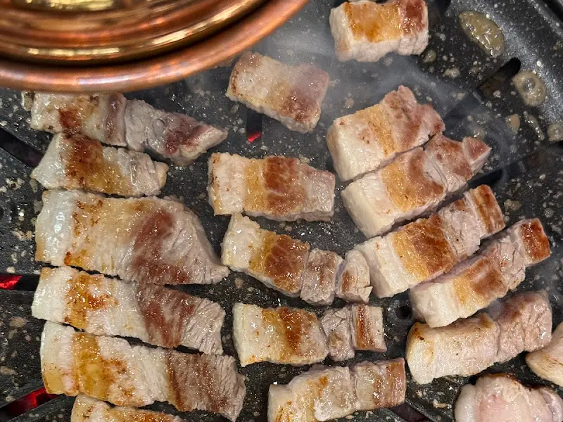 숯불 위에서 노릇하게 익어가는 돼지고기