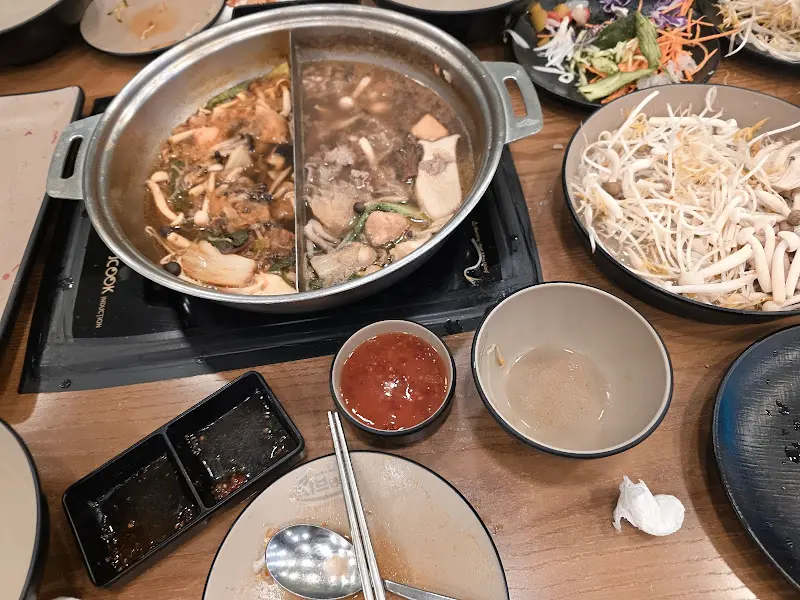 테이블 위에 놓인 샤브샤브 냄비와 빈 접시들